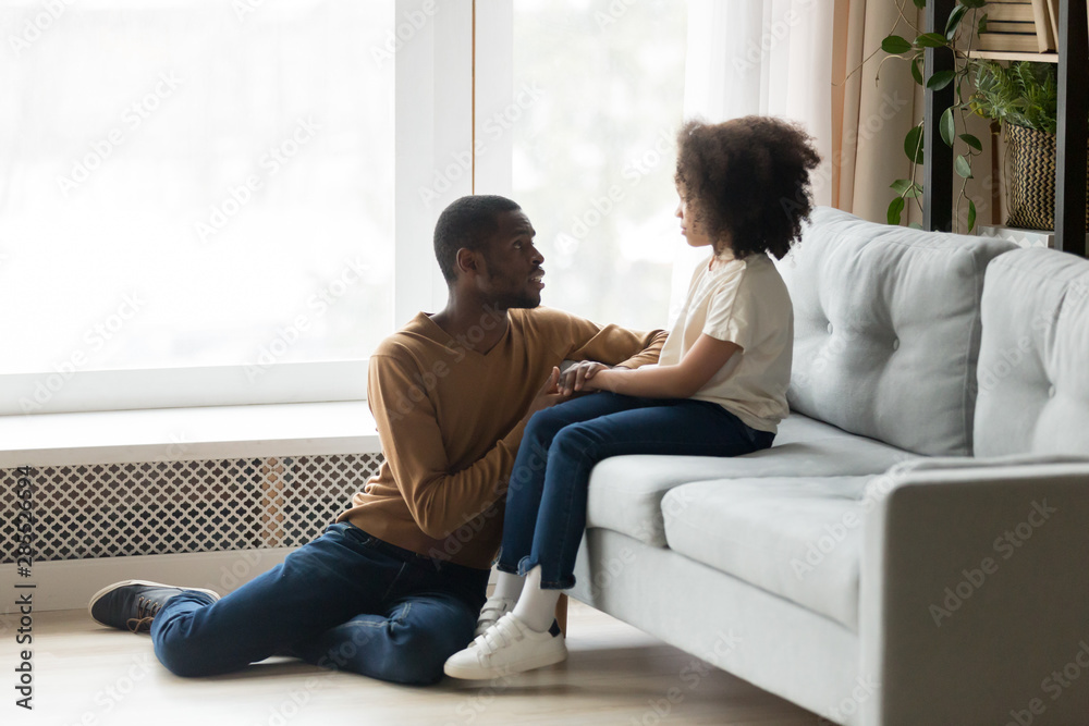 Caring African American father comforting adorable preschool daughter Caring African American father comforting adorable preschool daughter