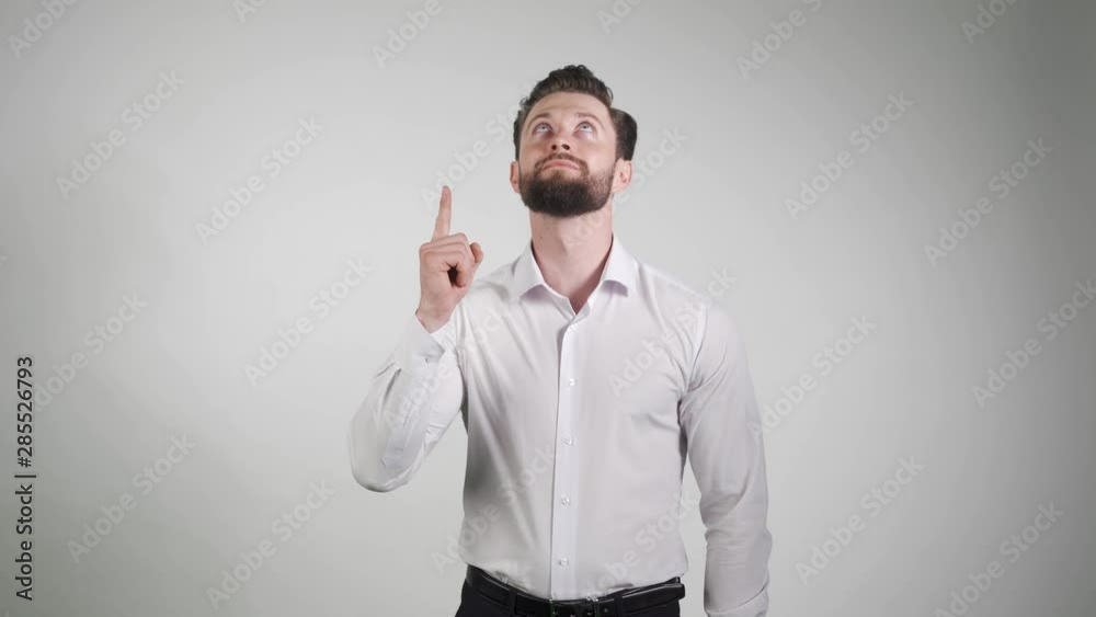 2 in 1. A young man showing something isolated on white background. Firstly pointing and looking up. Secondly pointing up and smiling.
