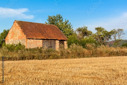 Old agricultural barn in the Czech Republic. Harvested field. Morning on the farm.