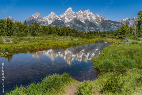 Schwabacher landing with river in the foreground and grand tetons in background mid summer blue sky