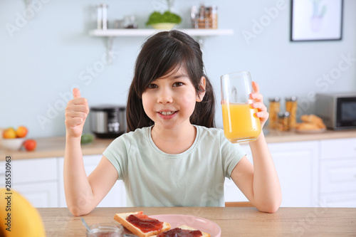 Funny little girl eating ta...