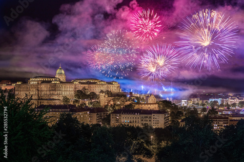 Budapest, Hungary - Illuminated Buda Castle Royal Palace with the 20th of August 2019 State Foundation Day fireworks by night. Szechenyi Chain Bridge at background photo