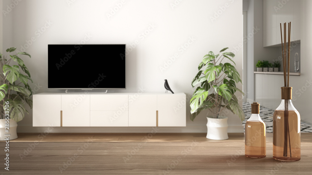 Wooden table top or shelf with aromatic sticks bottles over blurred modern scandinavian minimalist living room with tv, white architecture interior design Wooden table top or shelf with aromatic sticks bottles over blurred modern scandinavian minimalist living room with tv, white architecture interior design