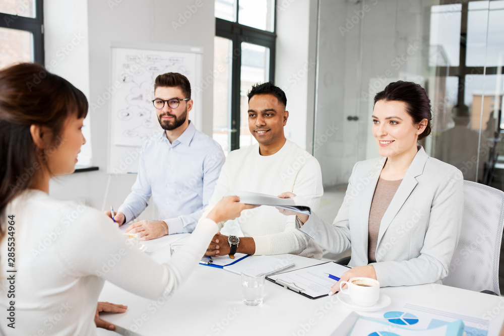 new job, hiring and employment concept - international team of recruiters having interview with female employee at office new job, hiring and employment concept - international team of recruiters having interview with female employee at office