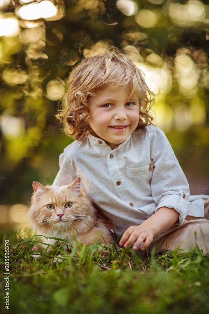 Little curly boy with a redhead cat, outdoor Little curly boy with a redhead cat, outdoor