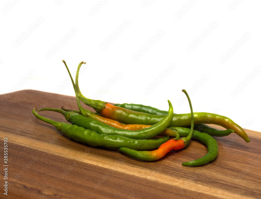 Chilli pepper pods on wooden background and bright background. Chilli pepper pods on wooden background and bright background.
