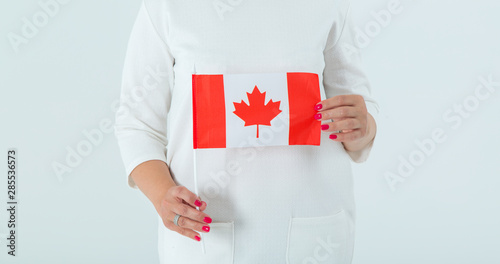 Close-up of the flag of Canada in female hands. Woman is Canadian.