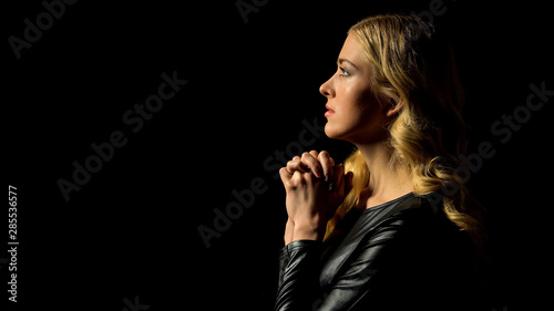 Sinner confession, young woman praying in darkness under heaven light, hope