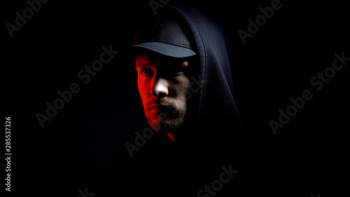 Foto Male isolated on black background, red lights, escape from prison, conspiracy