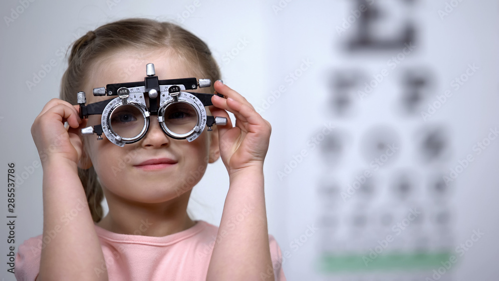 Pretty girl in optical trial frame smiling seeing clearly, vision correction Pretty girl in optical trial frame smiling seeing clearly, vision correction