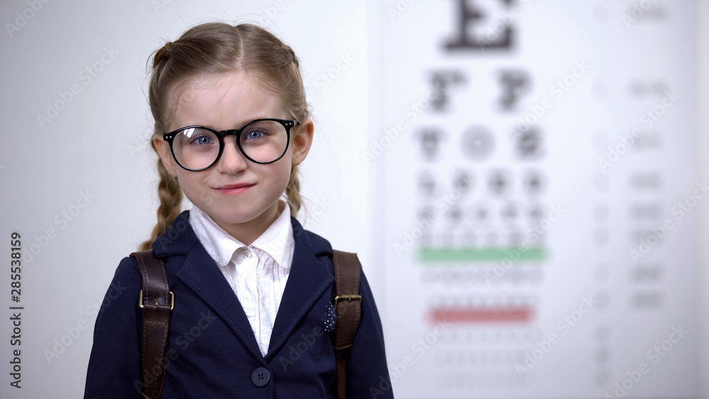 Happy girl in eyeglasses smiling into camera, ready for school with good vision Happy girl in eyeglasses smiling into camera, ready for school with good vision