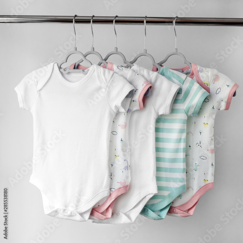 A set of beautiful clothes for a newborn girl on hangers. The concept of clothes, motherhood, fashion and newborn.