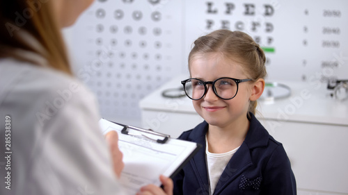 Cute smiling girl waiting eyeglasses prescription from optician, treatment tips