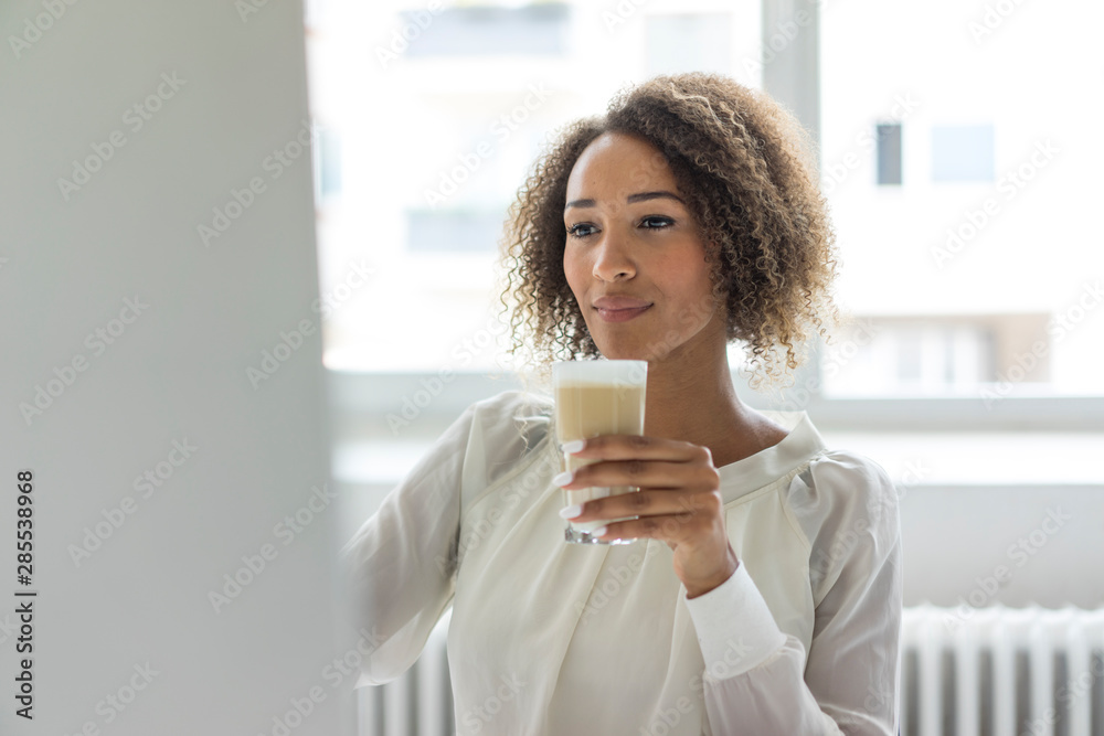 Young businesswoman with Latte Macchiato looking at computer Young businesswoman with Latte Macchiato looking at computer