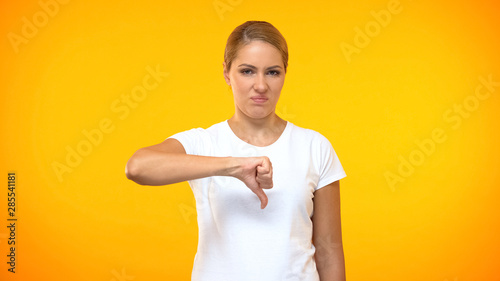 Konstfotografi Dissatisfied female showing thumbs down, negative feedback, wrong choice dislike
