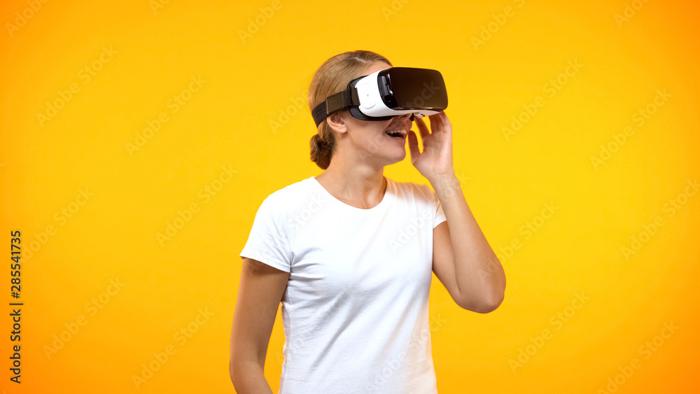 Excited young woman enjoying virtual reality wearing game headset, entertainment Excited young woman enjoying virtual reality wearing game headset, entertainment