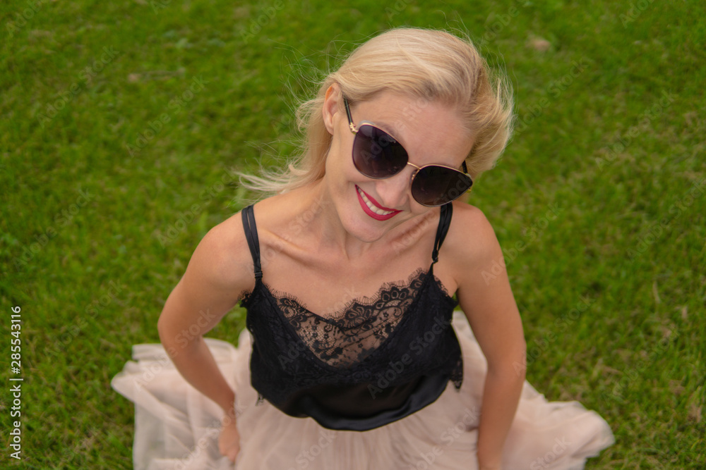 A girl loves a beautiful forest on the field with photochromic glasses behind. A girl loves a beautiful forest on the field with photochromic glasses behind.