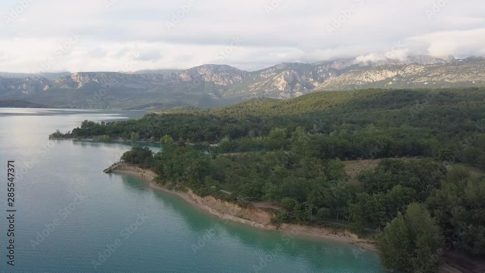 Raising up over the trees and over beautiful calm turquoise lake in Verdon France Raising up over the trees and over beautiful calm turquoise lake in Verdon France