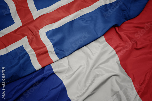 waving colorful flag of france and national flag of iceland.