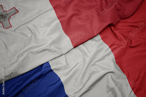 waving colorful flag of france and national flag of malta.
