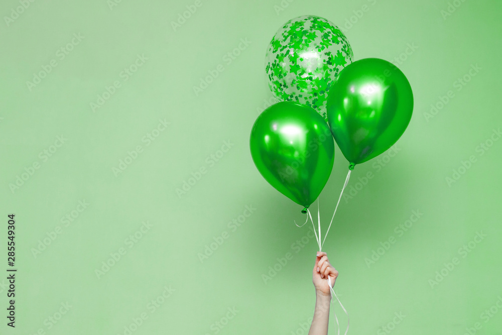 stylish birthday party or holidays with balloons. three green balloons on  the green background with copy space for text. Hand holding three bright  colorful balloons indoor. greeting background Stock Photo | Adobe
