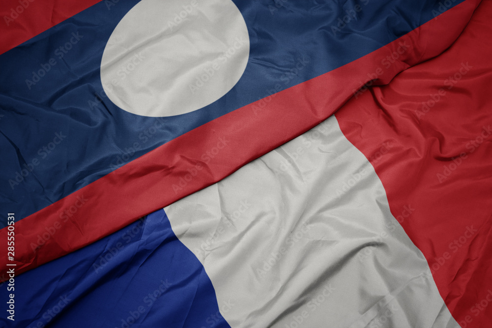 waving colorful flag of france and national flag of laos. waving colorful flag of france and national flag of laos.