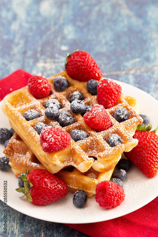 Two Classic Berry Waffles on a Rustic Blue Wood Table Two Classic Berry Waffles on a Rustic Blue Wood Table