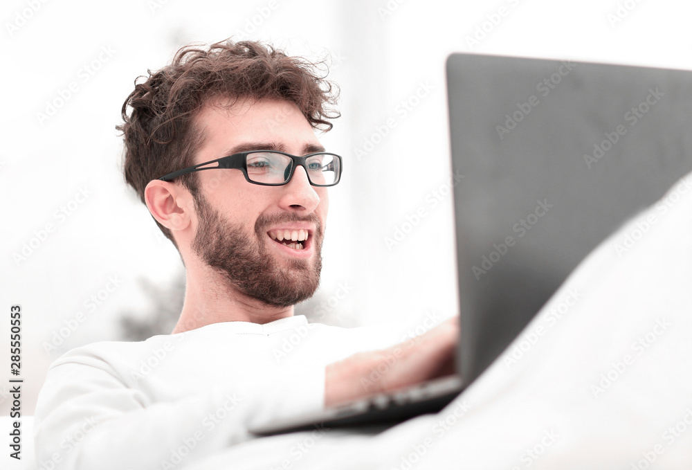 handsome man working on laptop lying on bed handsome man working on laptop lying on bed