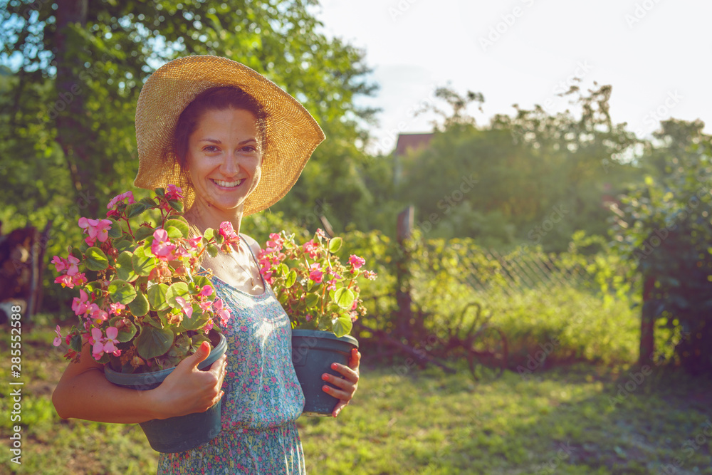 Happy Woman Planting Flowers At Her Backyard Stock Photo