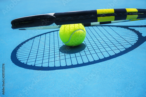 Summer sport concept with tennis ball and racket on blue hard tennis court. © IrynaV