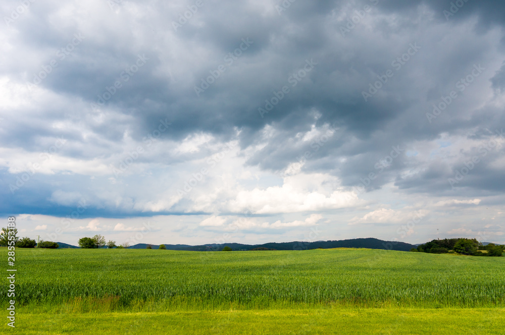 Dark stormy sky over green grass field Dark stormy sky over green grass field