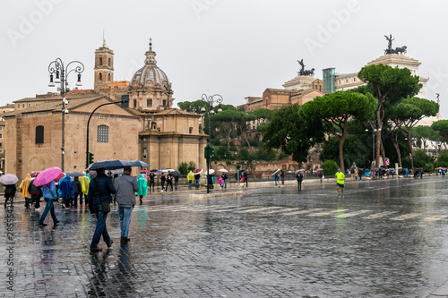 People walking on Via Dei Fori Imperiali Street. Vittorio Emanuele II Monument (Alter Of The Fatherland) built in honor of King Victor Emmanuel II the background in Rome, Italy