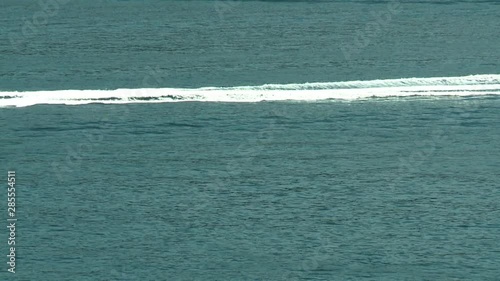 Steady, medium wide shot of a boat passing by.