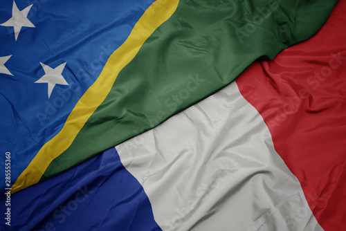 waving colorful flag of france and national flag of Solomon Islands , .