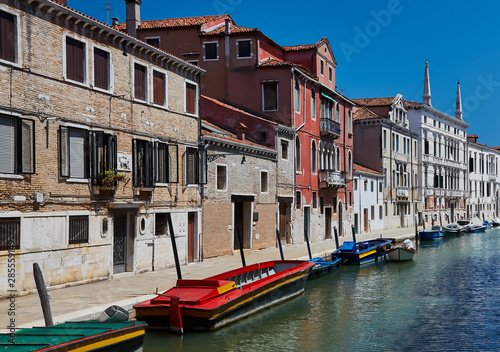 Traditional canal with boats in Venice, Italy. Summer