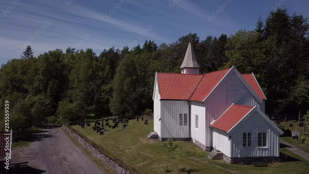 Aerial, drone shot, towards the Eide Church, a wooden red and white, parish cathedral, in Grimstad, on a sunny, summer day, in Aust-Agder, Norway Aerial, drone shot, towards the Eide Church, a wooden red and white, parish cathedral, in Grimstad, on a sunny, summer day, in Aust-Agder, Norway