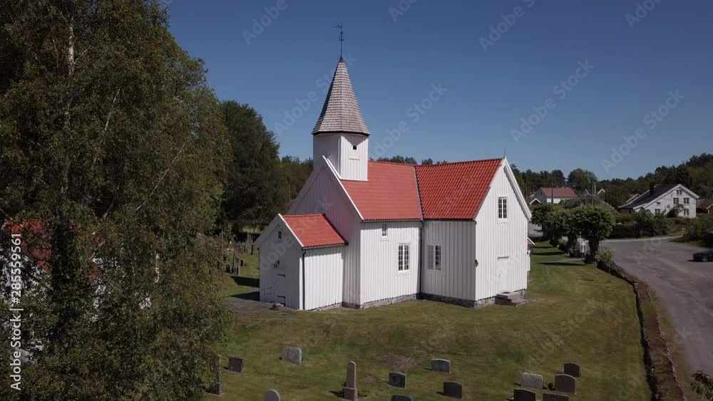 Aerial, drone shot, towards the Eide Church, a wooden red and white parish cathedral, in Grimstad, on a sunny, summer day, in Aust-Agder, Norway Aerial, drone shot, towards the Eide Church, a wooden red and white parish cathedral, in Grimstad, on a sunny, summer day, in Aust-Agder, Norway