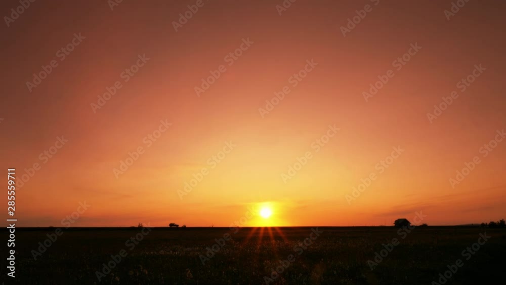 Backlit car traveling across the distant horizon at sunset Backlit car traveling across the distant horizon at sunset