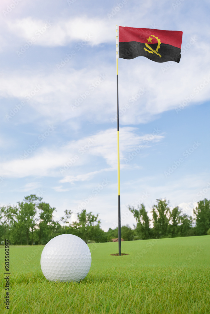 Obraz premium Angola flag on golf course putting green with a ball near the hole