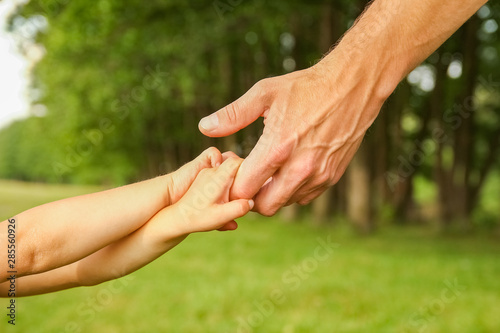 hands of a happy parent and child in nature © Kostia