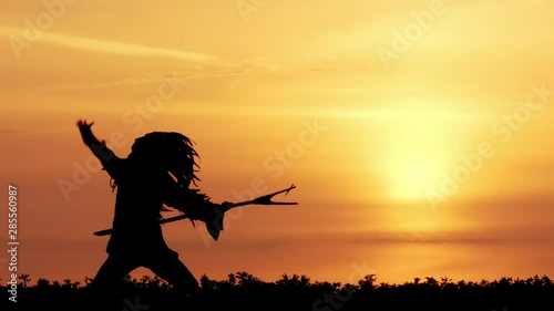 silhouette of Native American runs along the trail at sunset. went on the warpath. photo