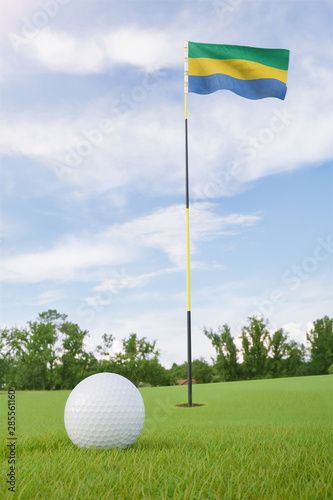 Gabon flag on golf course putting green with a ball near the hole
