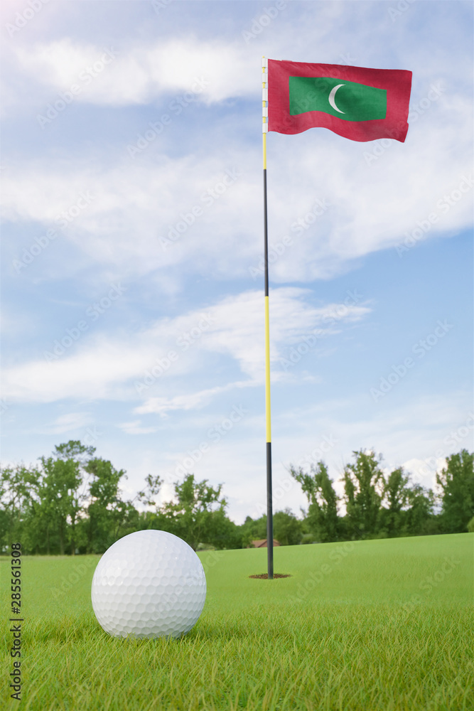 Obraz premium Maldives flag on golf course putting green with a ball near the hole