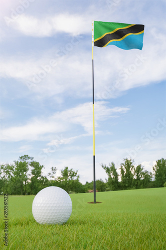 Tanzania flag on golf course putting green with a ball near the hole