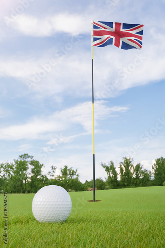 United Kingdom flag on golf course putting green with a ball near the hole