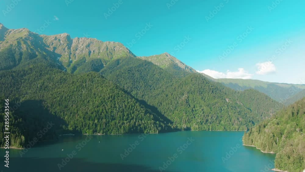 Mountain lake with turquoise water and green tree. Beautiful summer landscape with mountains, forest and lake. Aerial 4k View. Drone shot over a beautiful mountain forest lake Mountain lake with turquoise water and green tree. Beautiful summer landscape with mountains, forest and lake. Aerial 4k View. Drone shot over a beautiful mountain forest lake