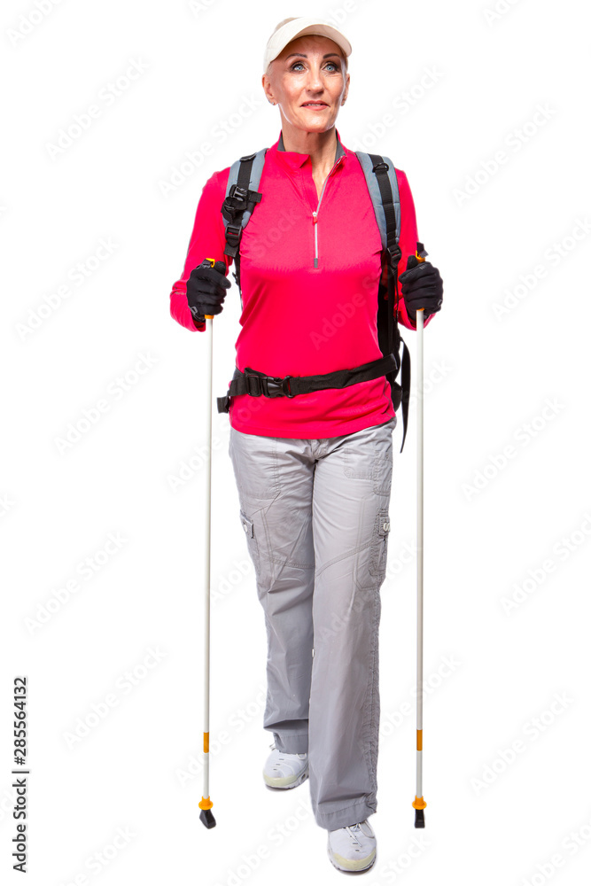 Full Length Portrait of Senior Caucasian Female with Backpack and Nordic Walking Sticks. Full Length Portrait of Senior Caucasian Female with Backpack and Nordic Walking Sticks.