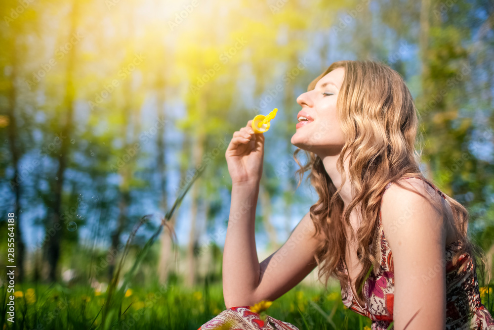 Portrait of Sensual Happy Caucasian Female Blowing Soap Bubbles Outdoors on Meadow.