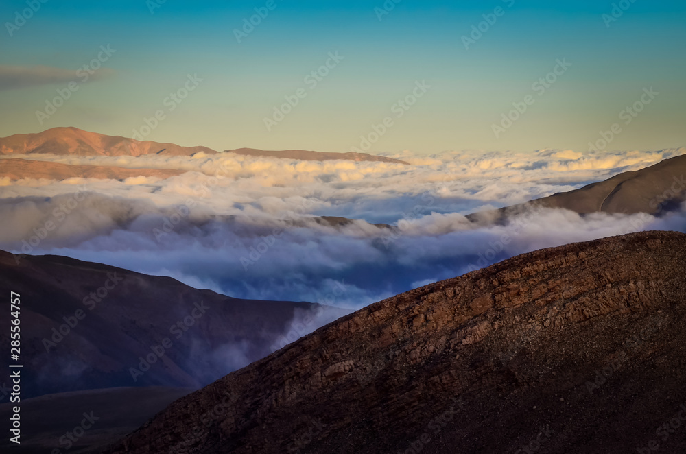 Cloud ground between arid reddish mountains