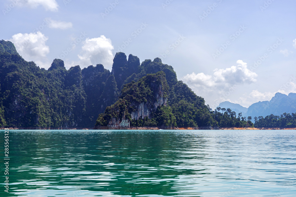 Limestone cliffs, islands, and mountain in green lake